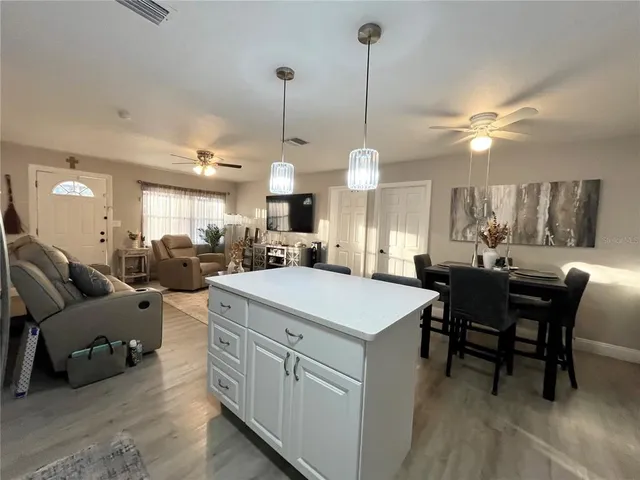 a large kitchen with kitchen island a sink table and chairs