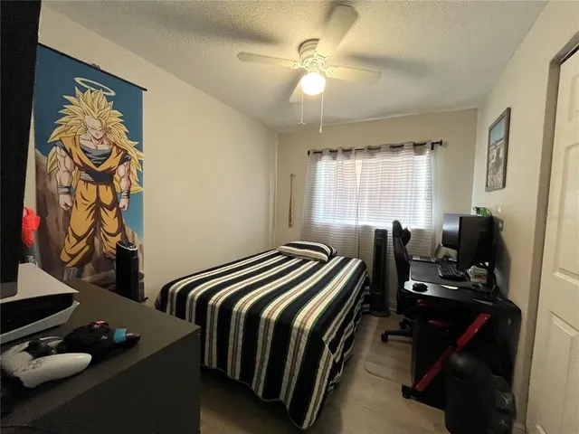 a bedroom with a bed and a flat tv screen on the dresser