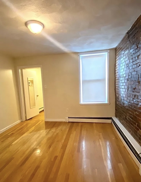 145 Princeton Street, Unit 2 Boston, MA 02128 - Photo 5 of 5 a view of an empty room with window and wooden floor