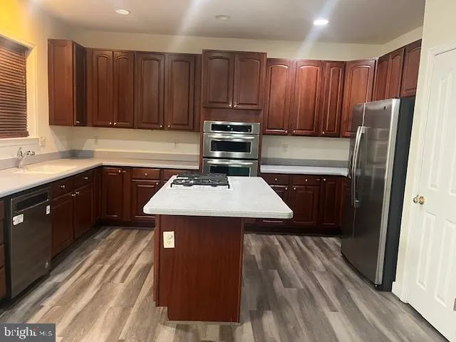 a kitchen with a sink a refrigerator and wooden cabinets