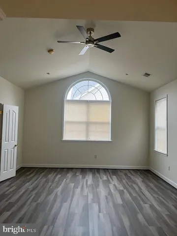 an empty room with a window and a ceiling fan