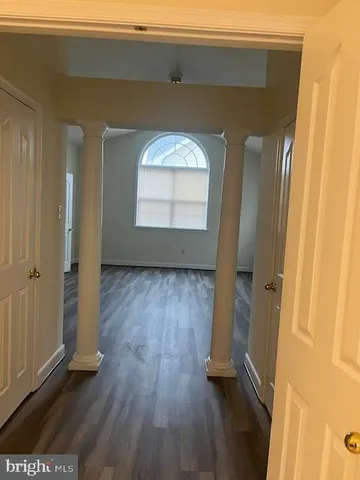 an empty room with wooden floor and a window