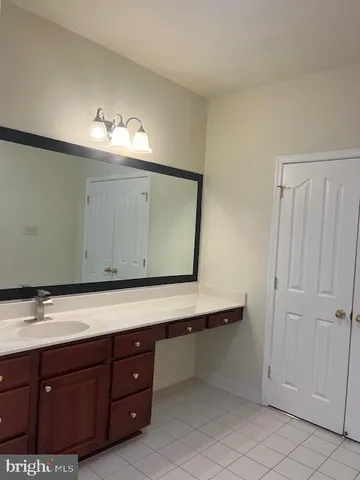 a bathroom with a sink vanity and mirror