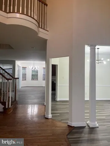 a view of a hallway with wooden floor and stairs