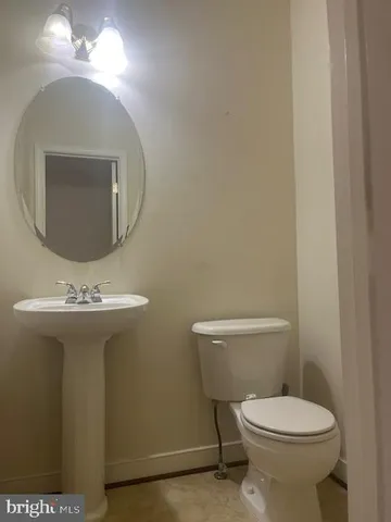 a bathroom with a toilet a sink and mirror