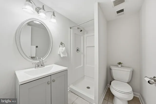 a bathroom with a toilet sink vanity and mirror