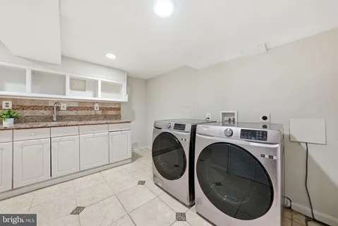 a utility room with sink dryer and washer