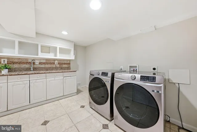a utility room with sink dryer and washer