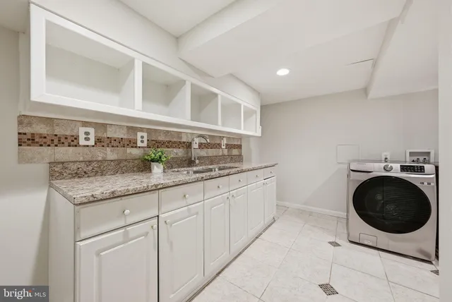 a kitchen with granite countertop a sink and a stove top oven