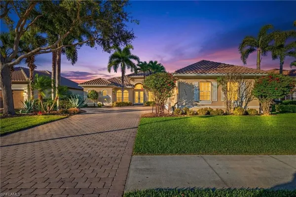 a front view of a house with a yard and potted plants