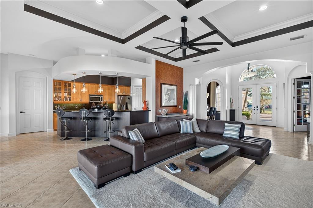 12095 Wicklow Lane Naples, FL 34120 - Photo 2 of 50 a living room with furniture a chandelier and a flat screen tv
