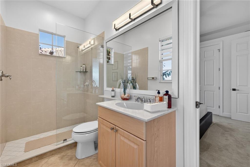 12095 Wicklow Lane Naples, FL 34120 - Photo 24 of 50 a bathroom with a sink toilet vanity and shower