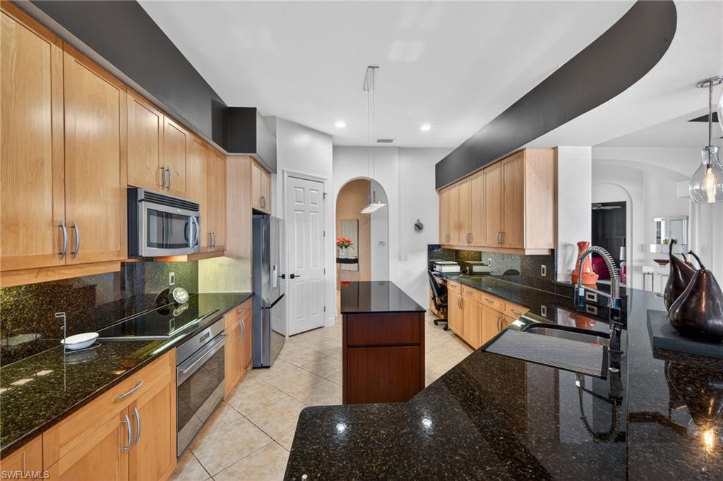 12095 Wicklow Lane Naples, FL 34120 - Photo 9 of 50 a large kitchen with stainless steel appliances a large counter top a stove and a wooden floors