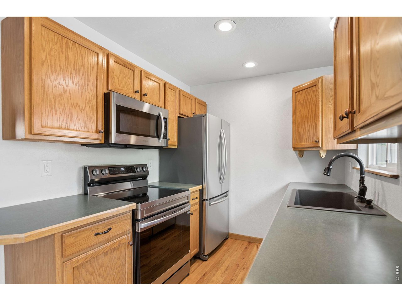 158 4th Street Firestone, CO 80520 - Photo 6 of 32 a kitchen with stainless steel appliances a sink a stove a microwave a refrigerator and cabinets