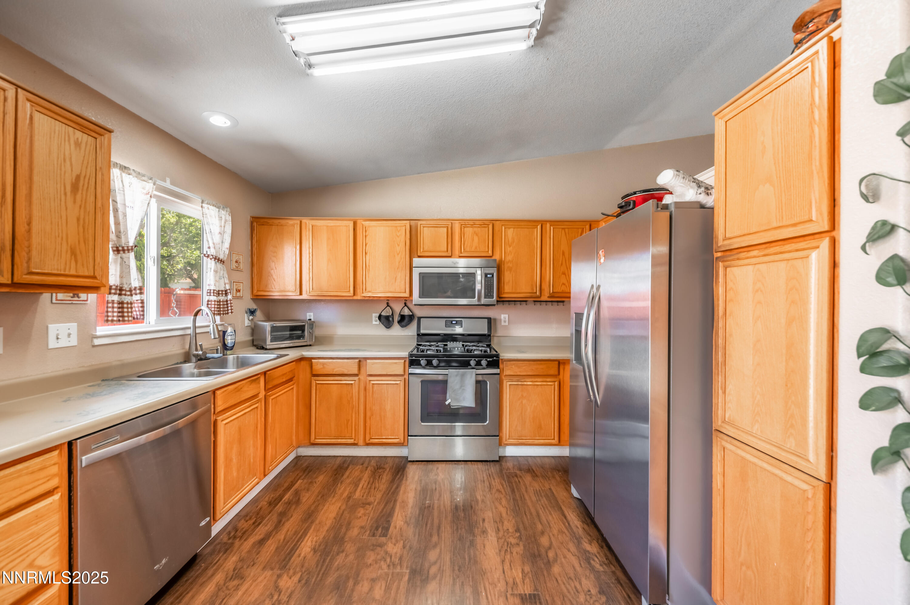 17523 Javalina Court Reno, NV 89508 - Photo 9 of 17 a kitchen with stainless steel appliances granite countertop refrigerator sink and wooden cabinets