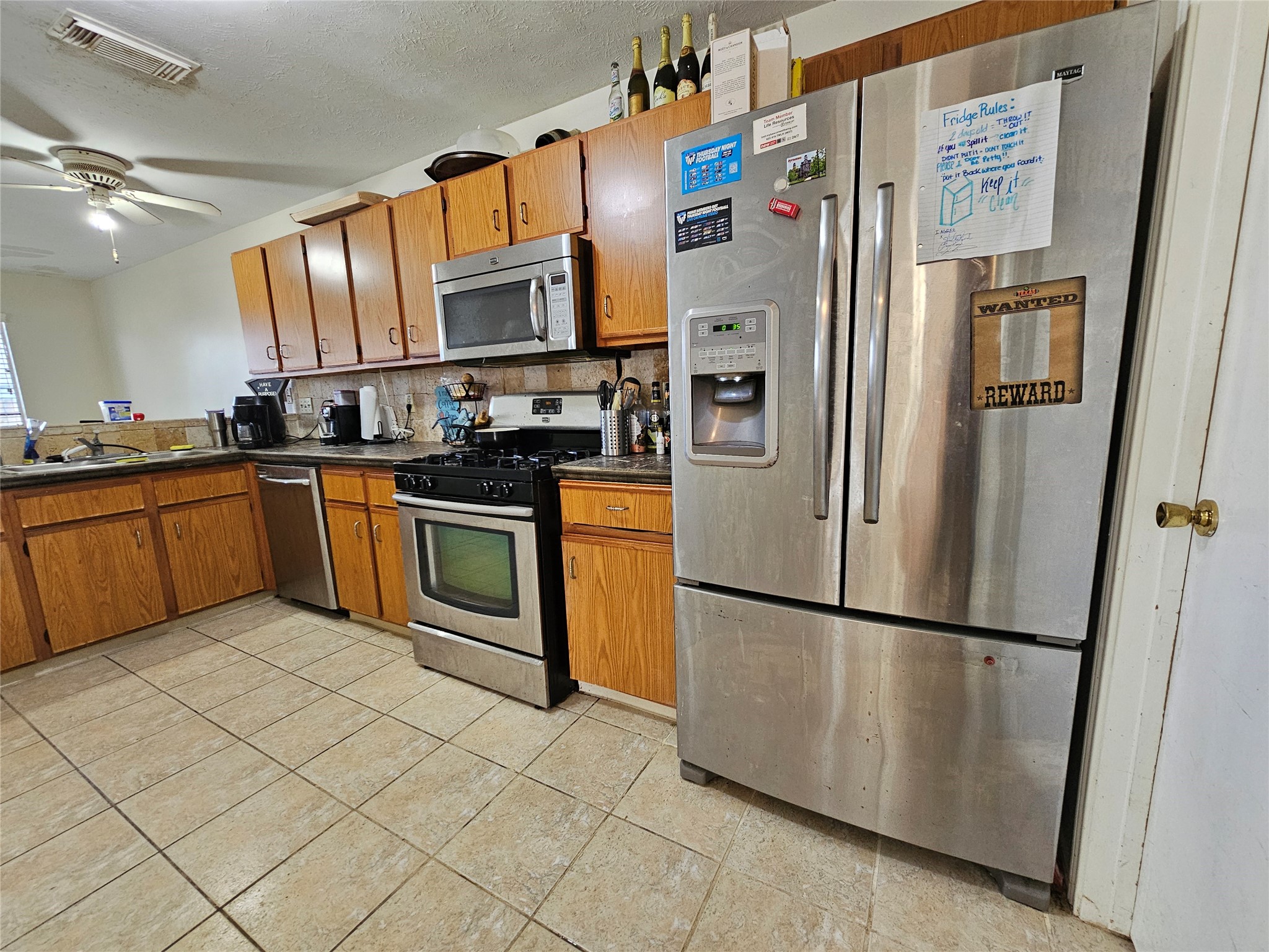 13615 Repa Lane Houston, TX 77014 - Photo 12 of 30 a kitchen with stainless steel appliances granite countertop a refrigerator a stove a sink and a microwave