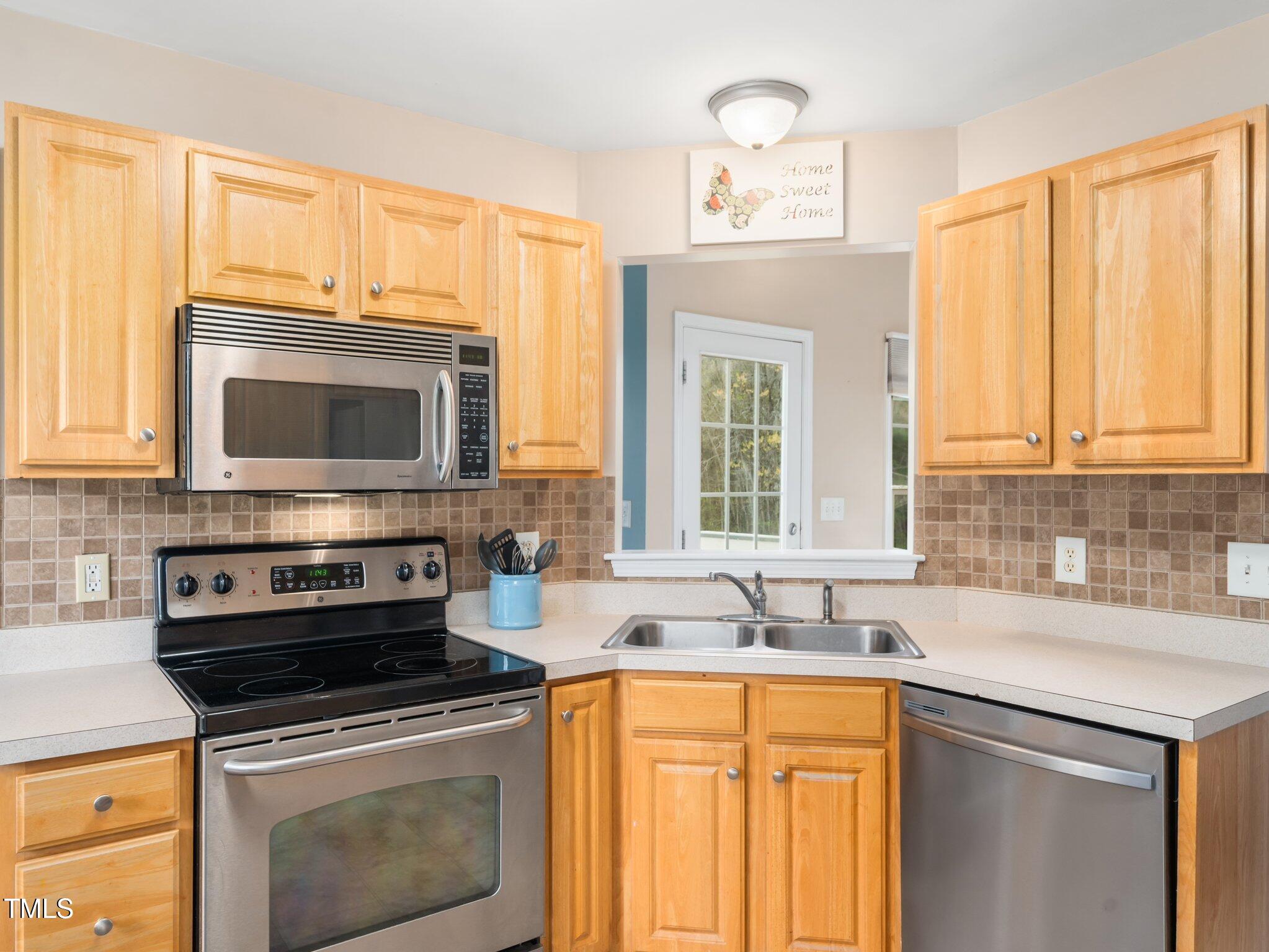 3690 Mabel Lane Stem, NC 27581 - Photo 10 of 37 a kitchen with stainless steel appliances granite countertop a sink stove and microwave