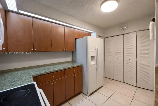 a kitchen with stainless steel appliances granite countertop a refrigerator and a stove