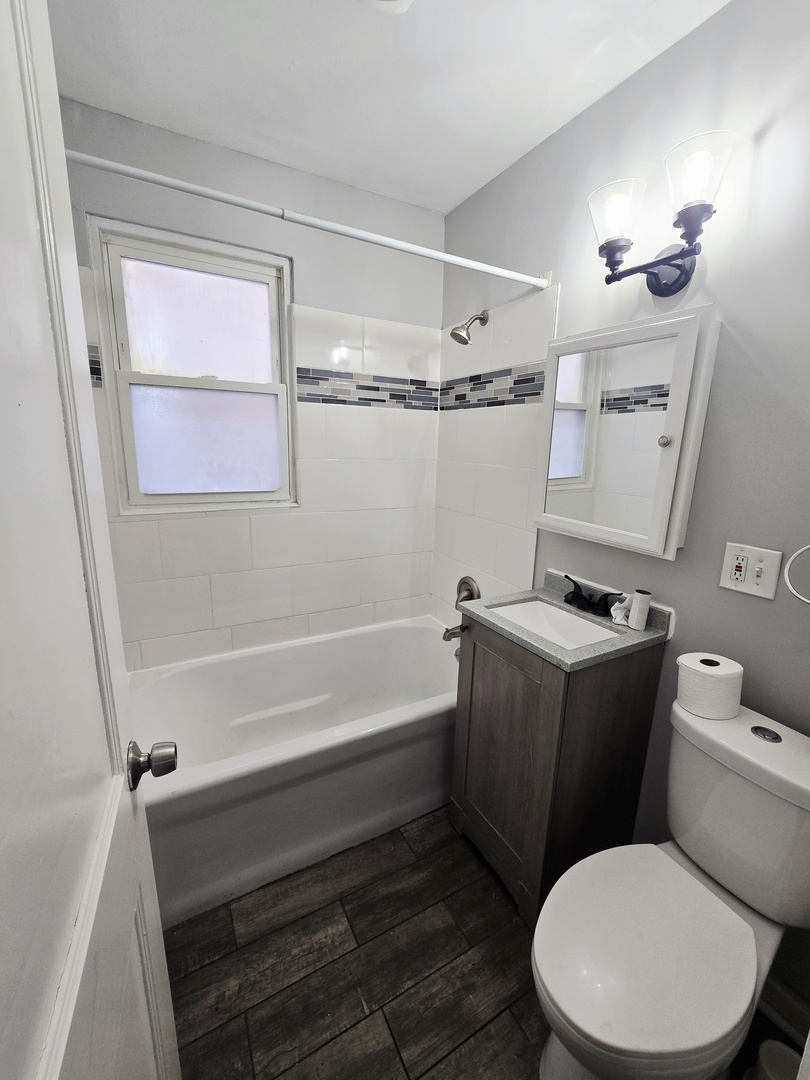 4819 West George Street, Unit 2 Chicago, IL 60641 - Photo 5 of 9 a bathroom with a toilet a sink and bathtub