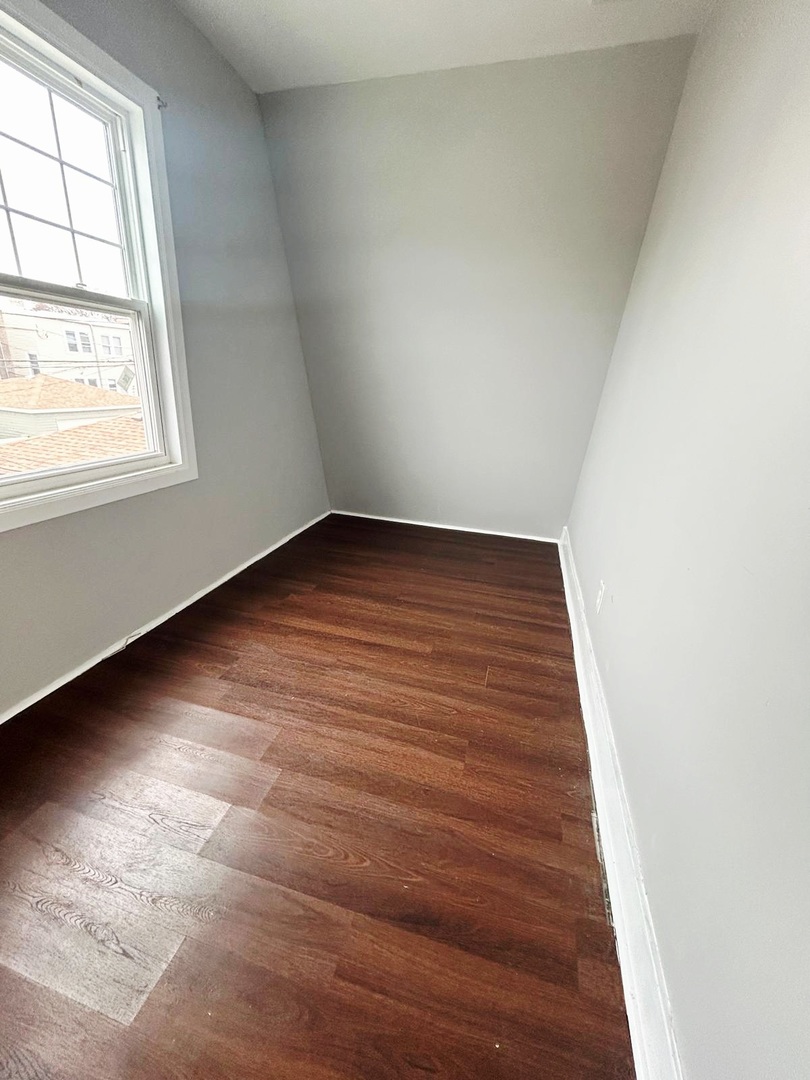 4819 West George Street, Unit 2 Chicago, IL 60641 - Photo 9 of 9 an empty room with wooden floor and windows