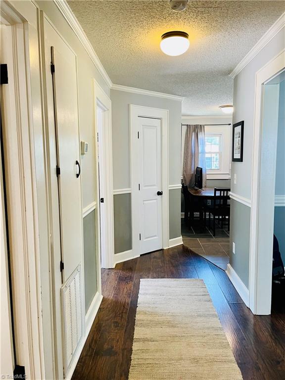 Nice, open hallway is in the center of the home, essentially connecting all rooms. This view is coming out of the bathroom. Bedroom #1 is immediately to the left. Bedroom 2 is down the hall on the left, followed by the pantry door. The kitchen entrance is on the far right. The den is immediately to the right.
