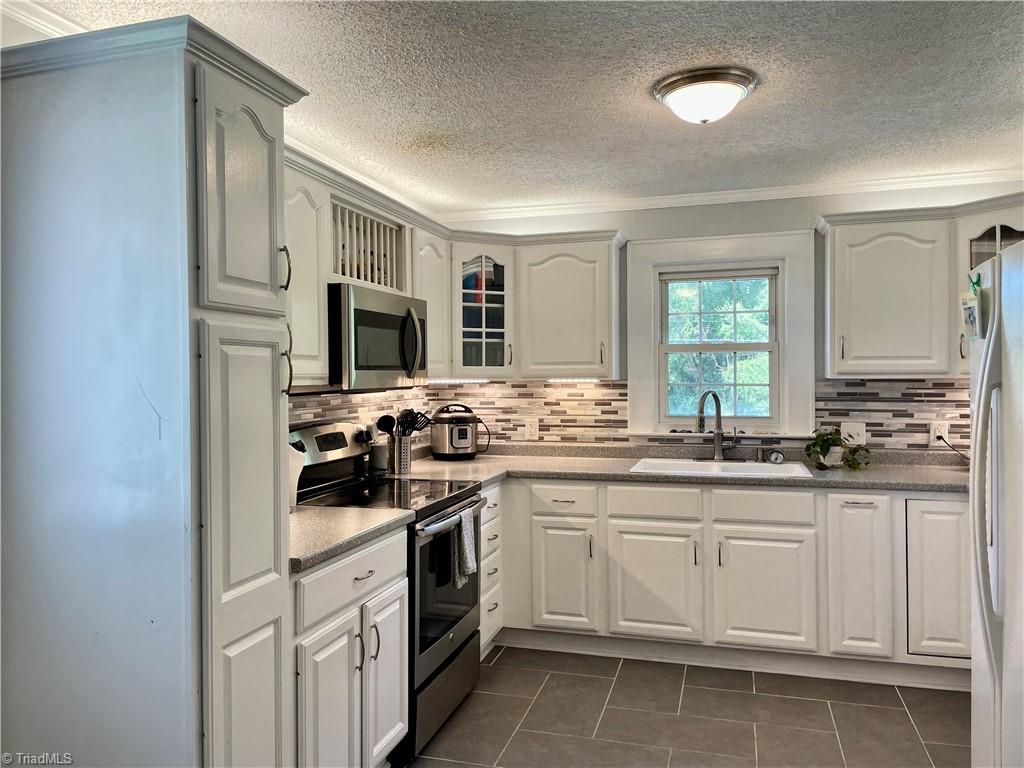 The kitchen has it's own exterior side entrance, perfect for carrying in groceries. The door is directly to the left of the tall cabinet