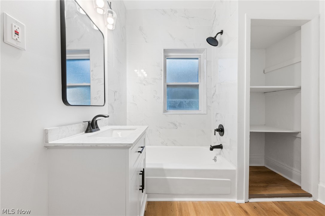 2140 Broadview Road Cleveland, OH 44109 - Photo 13 of 42 Bathroom featuring a healthy amount of sunlight, hardwood / wood-style flooring, tiled shower / bath combo, and vanity