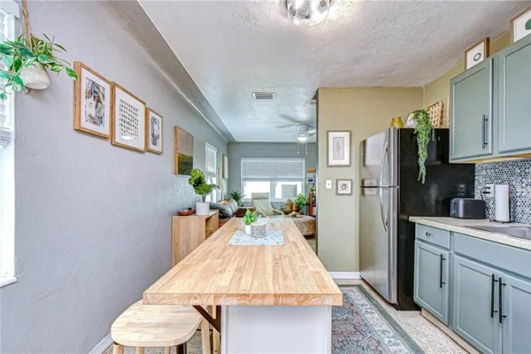 a kitchen with a table chairs refrigerator and cabinets