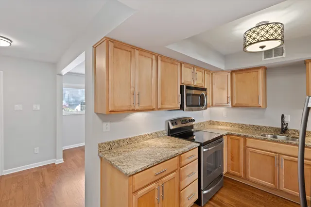 a kitchen with stainless steel appliances granite countertop a sink stove and cabinets