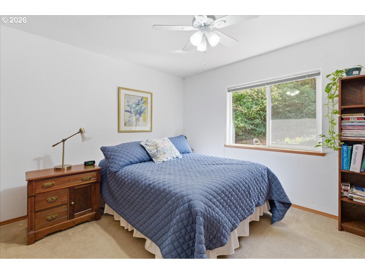 142 South Quadrant Street Rockaway Beach, OR 97136 - Photo 13 of 42 a bedroom with a bed dresser and a window