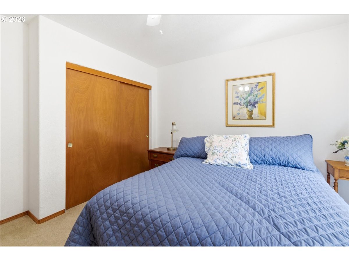 142 South Quadrant Street Rockaway Beach, OR 97136 - Photo 15 of 42 a bedroom with a large bed and a painting on the wall