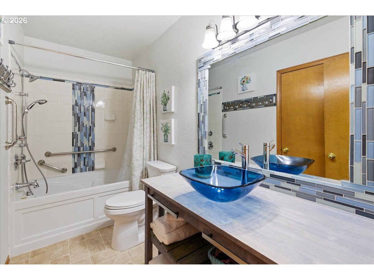 142 South Quadrant Street Rockaway Beach, OR 97136 - Photo 17 of 42 a bathroom with a granite countertop sink a toilet a mirror and shower