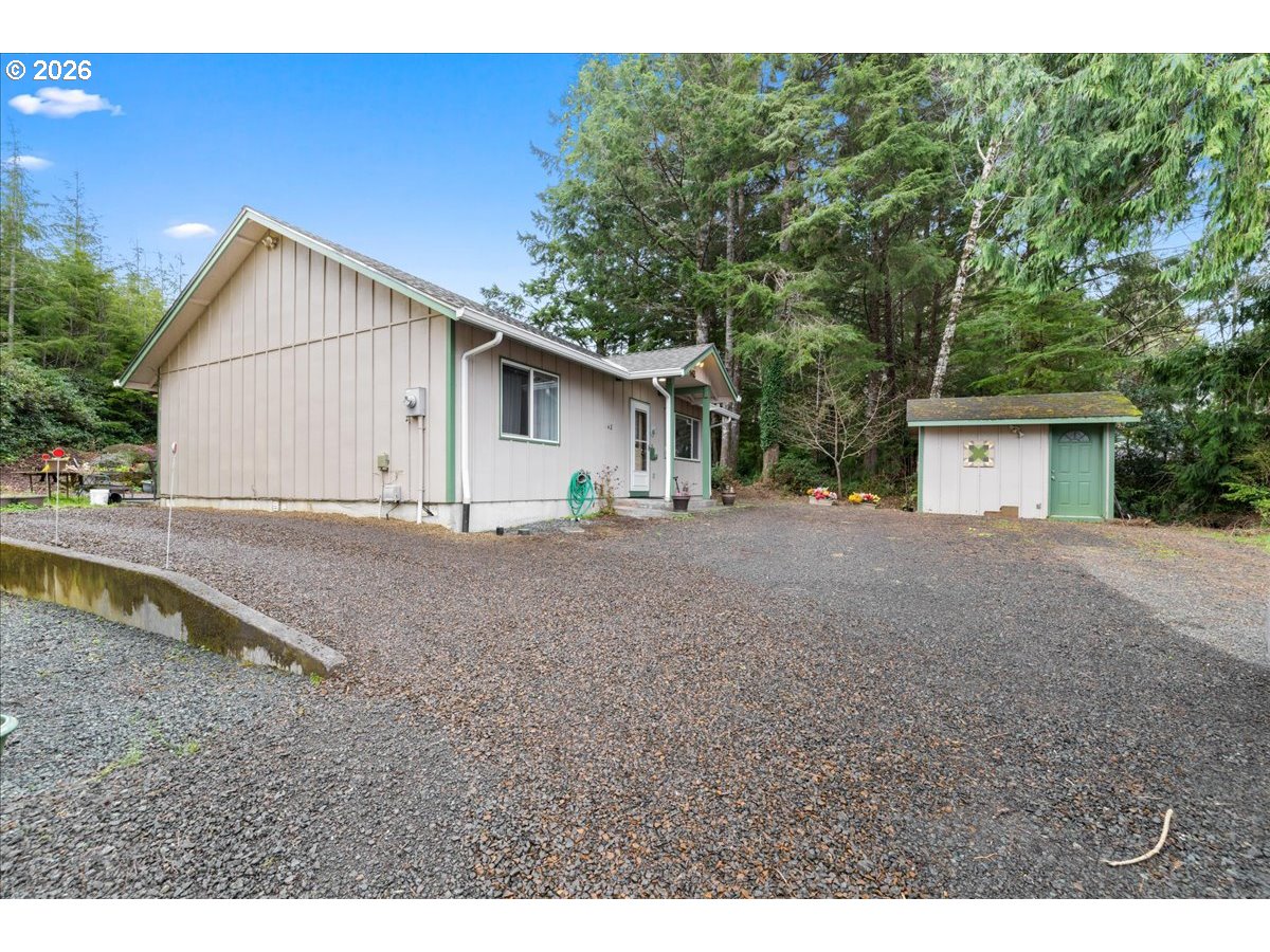 142 South Quadrant Street Rockaway Beach, OR 97136 - Photo 2 of 42 a view of a house with backyard and trees