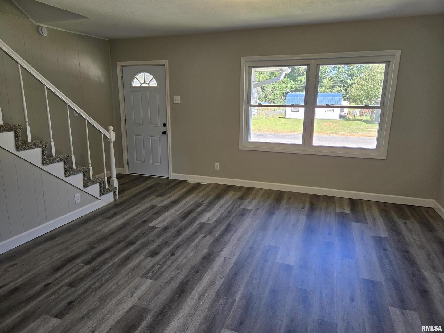 713 North 8th Street Herrin, IL 62948 - Photo 3 of 22 a view of an empty room with wooden floor and a window