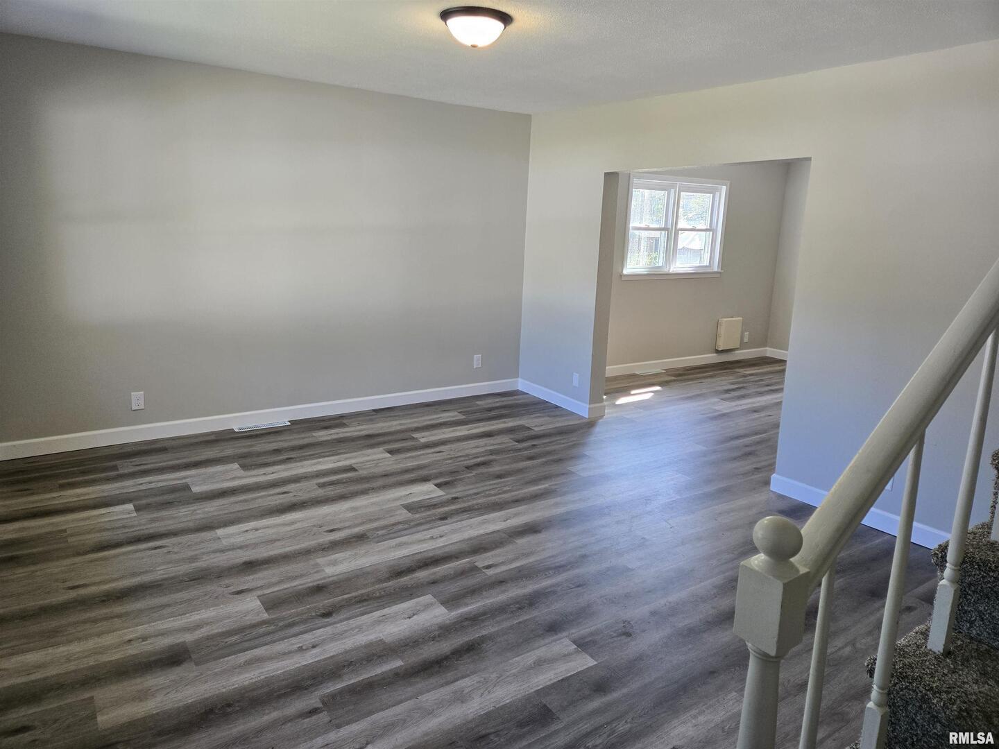 713 North 8th Street Herrin, IL 62948 - Photo 4 of 22 a view of an empty room with wooden floor and a window