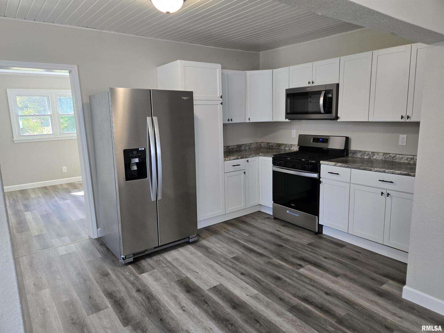 713 North 8th Street Herrin, IL 62948 - Photo 8 of 22 a kitchen with stainless steel appliances granite countertop a stove a refrigerator and a microwave