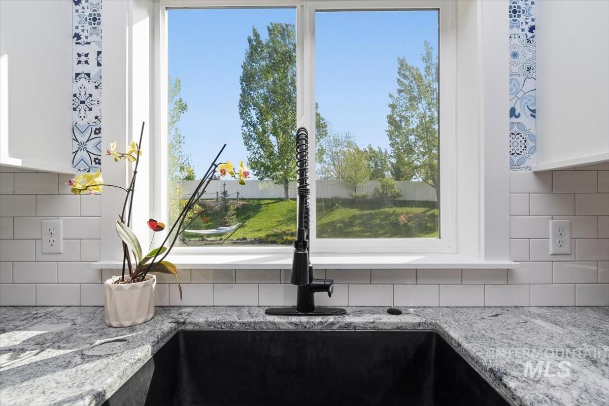 15015 Leon Lane Caldwell, ID 83607 - Photo 11 of 44 Kitchen sink featuring a matte black pull-down faucet, undermount basin, and stone-finish countertops