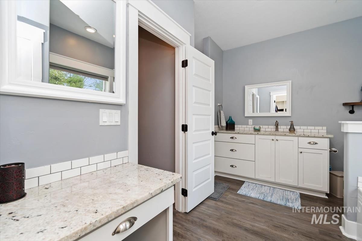 15015 Leon Lane Caldwell, ID 83607 - Photo 20 of 44 Bathroom featuring an extended vanity with dual sinks set in a light-colored stone countertop