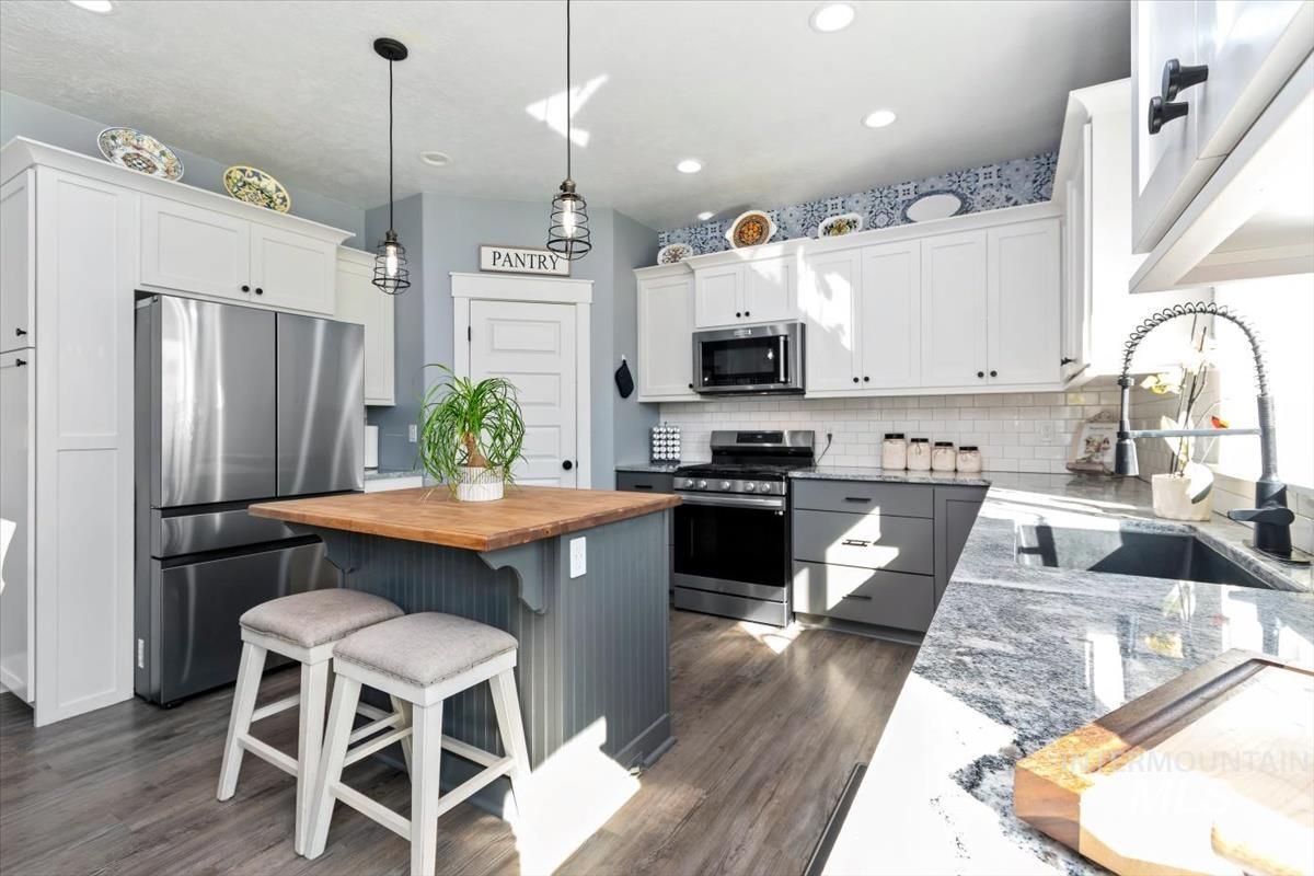 15015 Leon Lane Caldwell, ID 83607 - Photo 4 of 44 Kitchen featuring a two-tone cabinetry design, wood-finish flooring, and recessed ceiling lighting