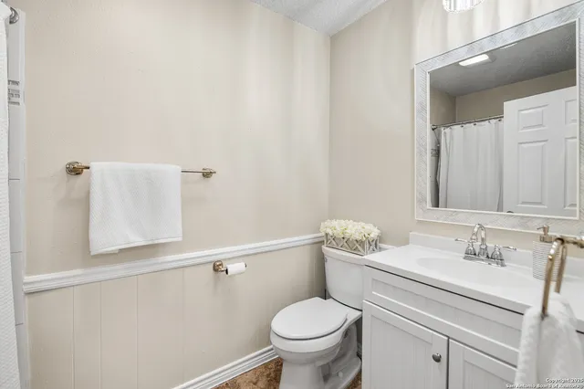 a bathroom with a sink vanity mirror and toilet