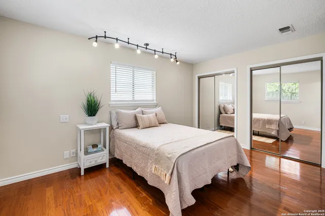 a bedroom with a bed and wooden floor