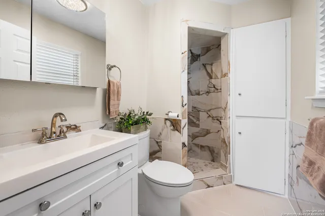 a bathroom with a sink a toilet and shower curtain