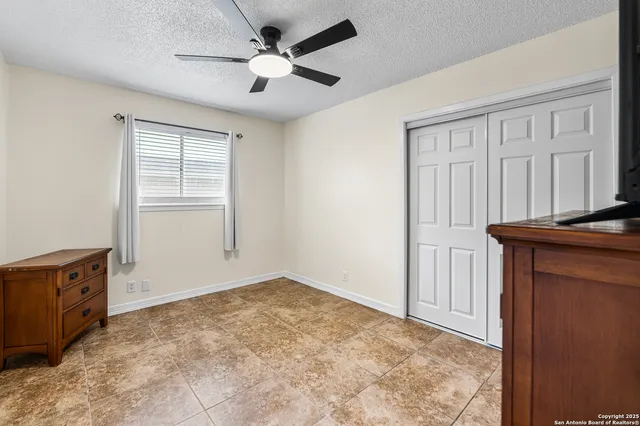 an empty room with windows and cabinet