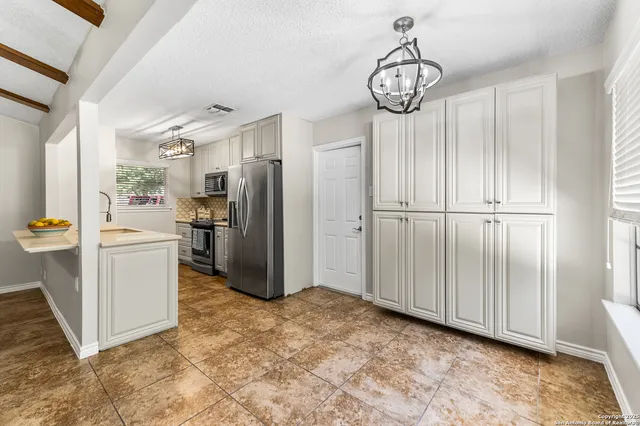 a view of a kitchen with refrigerator and mirror