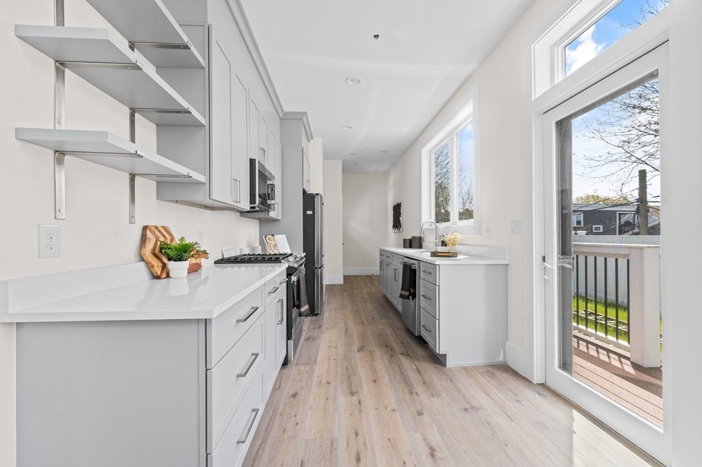 120 School Street, Unit 3 Boston, MA 02119 - Photo 8 of 30 a kitchen with stainless steel appliances granite countertop a lot of counter space and wooden floors
