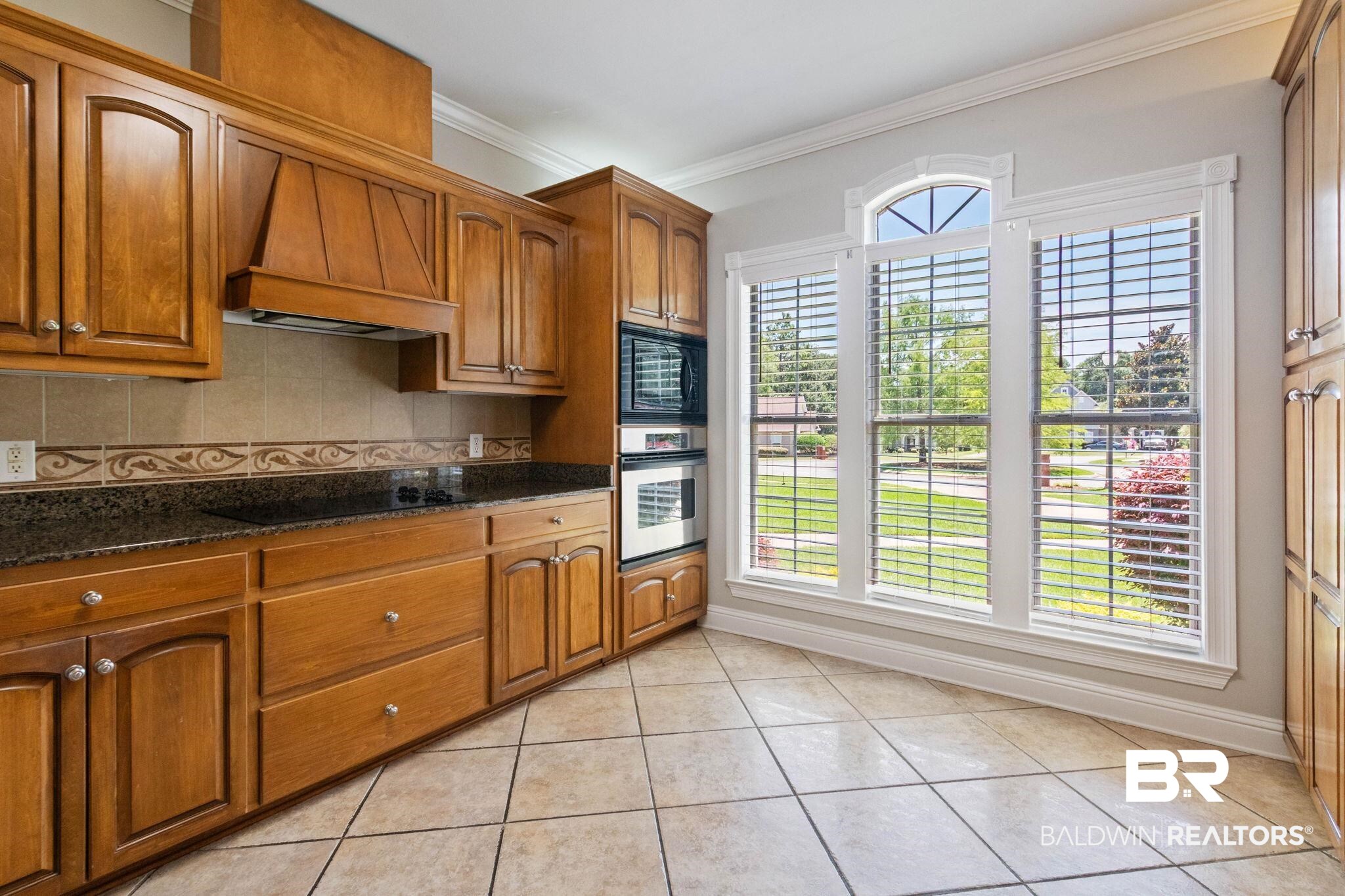 3176 Cedar Court Mobile, AL 36619 - Photo 11 of 33 Kitchen featuring wood cabinetry, dark countertops, built-in double ovens, and tile flooring