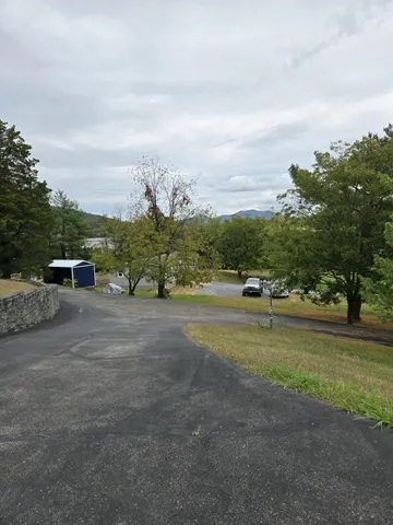 a view of a yard with car parked in front of it