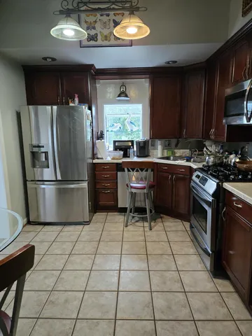 a kitchen with stainless steel appliances granite countertop a stove refrigerator sink and cabinets