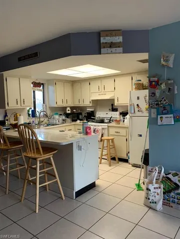 a kitchen with stainless steel appliances a table and chairs in it