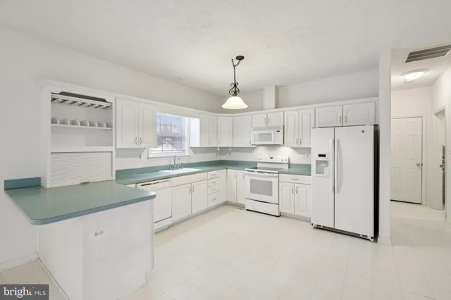 a kitchen with white cabinets and white appliances